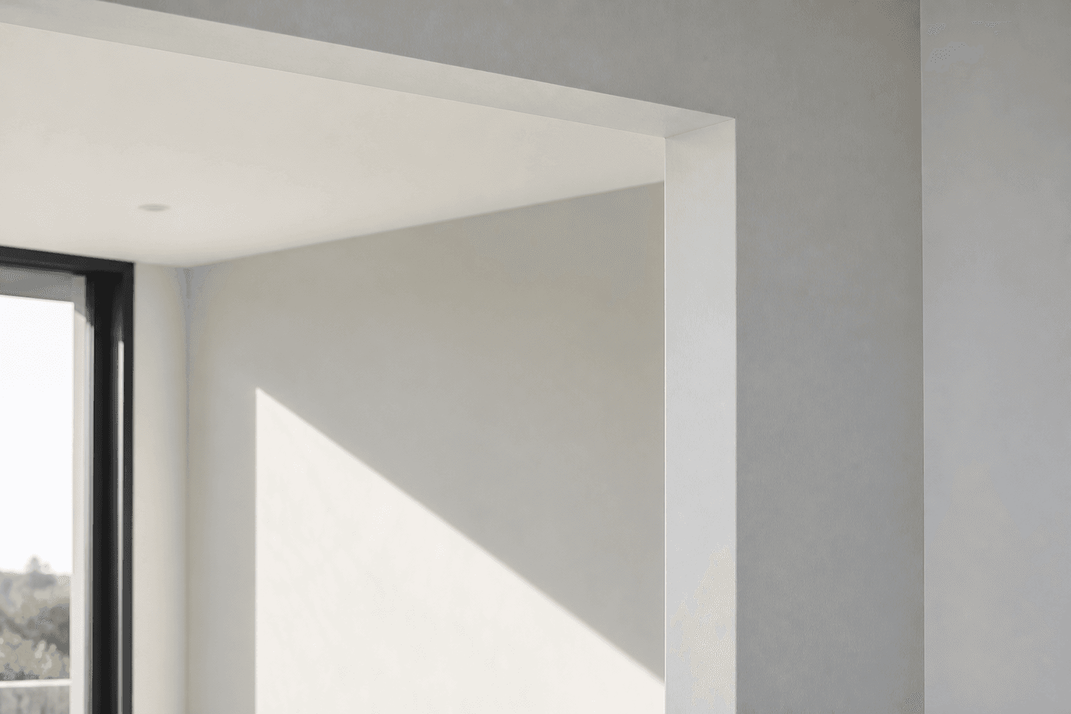 Close view of a precise plasterboard doorway reveal in natural side light
